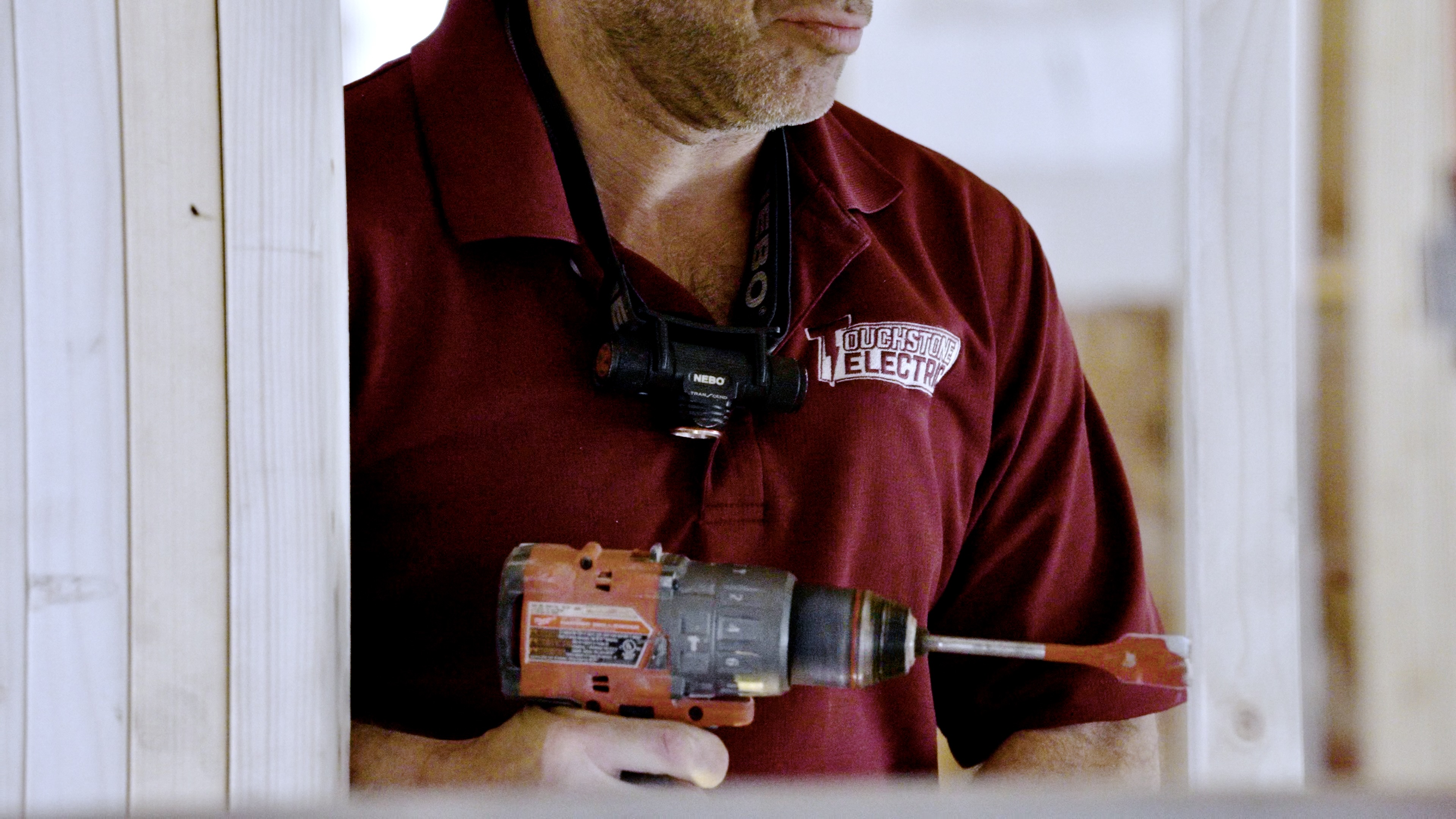 Touchstone Electric drilling studs for wiring during an Oak Grove electrical project
