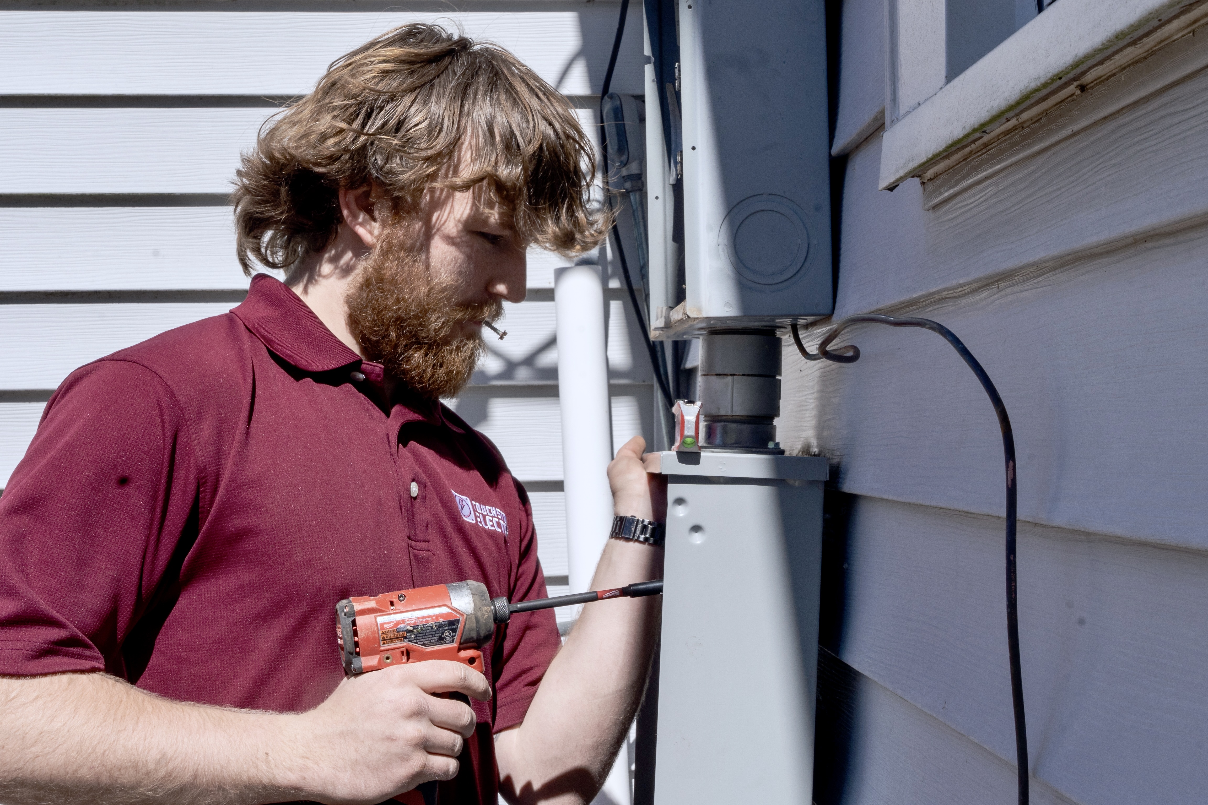 Touchstone Electric technician reviewing exterior electrical service equipment